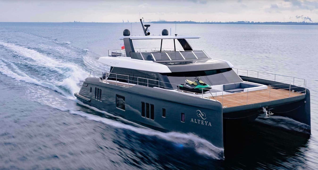 Catamaran underway with a Jet Ski on its aft deck