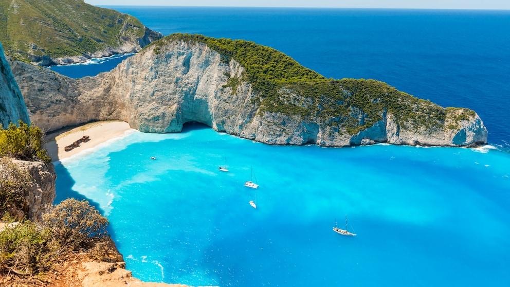 Navagio (Shipwreck) Beach on Zakynthos, Greece, with a rusted shipwreck on the white sand beach surrounded by steep limestone cliffs and turquoise water